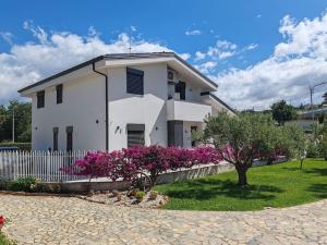 ein weißes Haus mit rosa Blumen davor in der Unterkunft Eco Appartamento Mediterraneo in Catanzaro