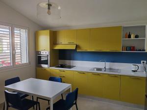 eine Küche mit gelben Schränken und einem Tisch mit Stühlen in der Unterkunft Eco Appartamento Mediterraneo in Catanzaro + 15 Fotos