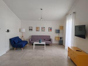 ein Wohnzimmer mit einem lila Sofa und einem Tisch in der Unterkunft Eco Appartamento Mediterraneo in Catanzaro