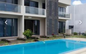 a villa with a swimming pool in front of a building at Le Bouchon Public Beach Apartment in Bouchon
