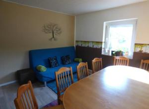 un soggiorno con un tavolo e un divano blu di Ferienwohnung Waldblick Schönbronn a Buch am Wald Altre 22 foto