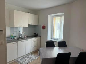 a kitchen with white cabinets and a table with chairs at Villa Ivanka in Koper