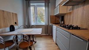 a kitchen with a table and a stove and a counter at Apartament Classic in Malbork