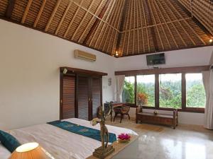 1 dormitorio con 1 cama en una habitación con ventanas en Toya Retreat Villa, en Tegalalang