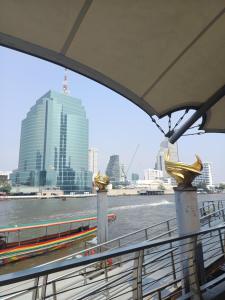 un bateau sur une rivière avec des bâtiments en arrière-plan dans l'établissement Longtail Boat Tour bangkok Tour Klong, à Chinatown