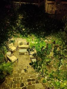 a patio with couches and lights in a garden at night at Hacienda Las Amantes in San Miguel de Allende