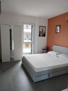 a bedroom with a large white bed and a window at Relax Apartment in San Salvo