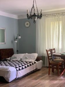 a bedroom with a bed and a clock on the wall at Apartament Classic in Malbork