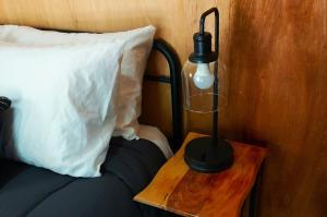 a lamp on a wooden table next to a bed at Applegate Cabin 2 in O'Brien
