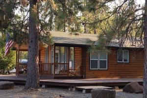 a log cabin with a porch and a flag at The Lodge in O'Brien