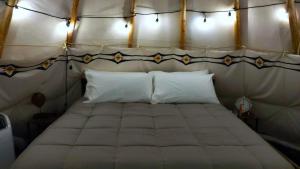 a bedroom with a large bed in a tent at Wild Horses Luxury Tipi - Adjustable King Bed in O'Brien