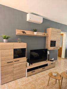 a living room with a large entertainment center with a flat screen tv at The White Village in Aldea Blanca