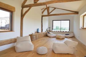 a living room with white furniture and wooden ceilings at Gites&chambres d hôtes Les granges du Fournel in Saint-Lattier