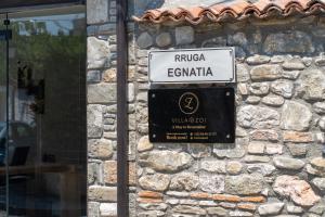 un cartello stradale sul lato di un muro di pietra di Villa Zoi A Stay to Remember I Located inside the Castle of Elbasan, on a historic Roman road Via Egnatia I Homemade Breakfast a Elbasan