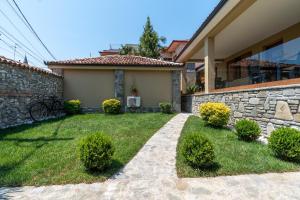una casa con un muro di pietra e un cortile di Villa Zoi A Stay to Remember I Located inside the Castle of Elbasan, on a historic Roman road Via Egnatia I Homemade Breakfast a Elbasan