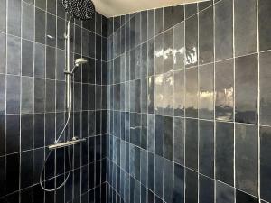 a bathroom with a shower with blue tiled walls at Gare Unique Duplex lumineux in Amiens