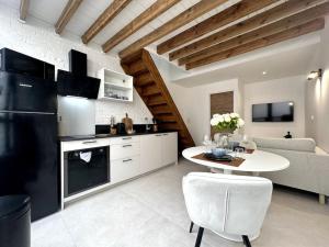 a kitchen and living room with a table and a couch at Gare Unique Duplex lumineux in Amiens