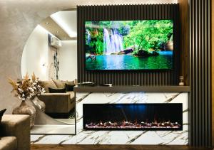 a living room with a fireplace with a tv above it at Spa Prestige Apartman Brcko in Brčko