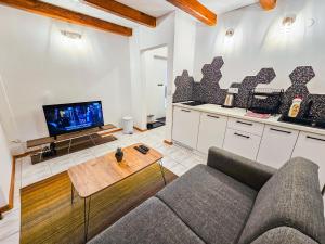 a living room with a couch and a tv at GlowLeaf Loft in Sarajevo