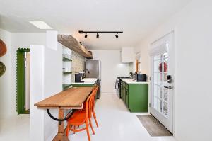 a kitchen with a wooden table and green cabinets at Dos Hermanas Casita 1 Downtown Courtyard in Santa Fe