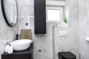 a bathroom with a white sink and a mirror at Apartment Jasna in Splitska