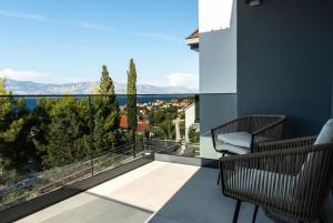 a balcony with two chairs and a view of the mountains at Apartment Jasna in Splitska +23 photos