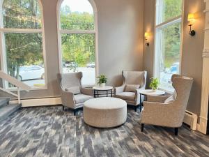 a waiting room with chairs and a table and windows at Town & Country Inn & Resort in Gorham