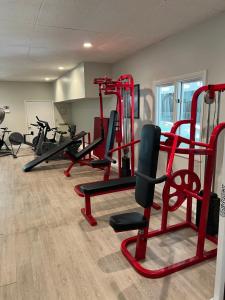 a gym with several tread machines in a room at Town & Country Inn & Resort in Gorham