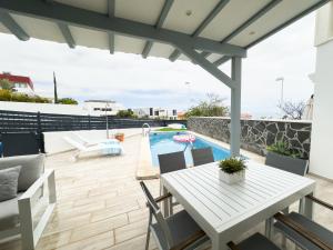a patio with a table and a swimming pool at Tranquil 2BR :Private Pool & Ocean Views in Callao Salvaje