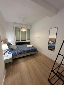 a bedroom with a bed and a mirror on the wall at Dulces Sueños Amistad in Valencia