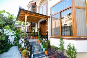 a house with a porch with potted plants on the stairs at Vila Rivaaa in Berat