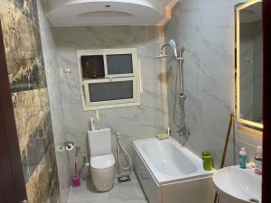 ein kleines Badezimmer mit Toilette und Waschbecken in der Unterkunft شقة فندقية غرفتين بكمبوند قرب ميدان جهينة in Sheikh Zayed + 27 Fotos
