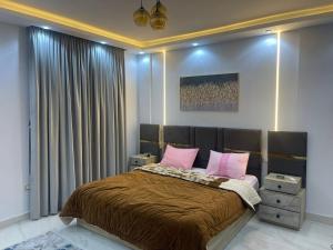 ein Schlafzimmer mit einem großen Bett mit rosa Kissen in der Unterkunft شقة فندقية غرفتين بكمبوند قرب ميدان جهينة in Sheikh Zayed