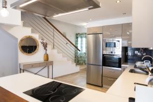 a kitchen with white walls and a staircase with stainless steel appliances at Tranquil 2BR :Private Pool & Ocean Views in Callao Salvaje