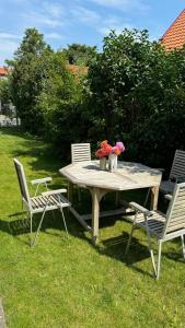 a picnic table with two chairs and flowers on it at Unikt boende i egen del av hus nära stad och strand in Ystad +2 photos