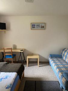 a room with a couch and a table and a desk at Samostatný apartmán se zahradou in Bedřichov