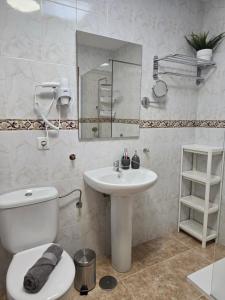 a bathroom with a sink and a toilet and a mirror at The White Village in Aldea Blanca +34 photos