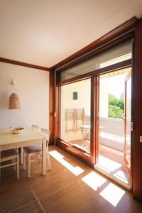 Un comedor con una mesa y un gran ventanal. en Sunny Troia beach apartment, en Tróia