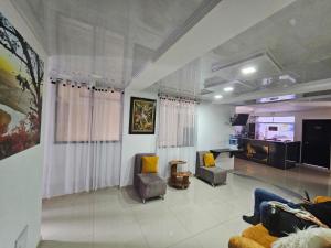 a living room with two chairs and a television at HOTEL BIG BEN MALAGA SANTANDER in Málaga