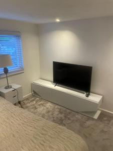 a bedroom with a flat screen tv on a wall at Room in Cheshunt in Cheshunt