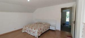 a bedroom with a bed in a white room at Casa na Montanha in Campos do Jordão
