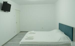 a bedroom with a white bed with two towels on it at M & M Studio in Jurilovca
