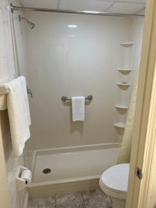 a bathroom with a shower with a toilet and towels at Town & Country Inn & Resort in Gorham