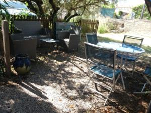 a patio with chairs and a table and a bench at Maison de village dans Languedoc-Roussillon in Vergèze