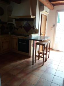 a kitchen with a table and two stools at Maison de village dans Languedoc-Roussillon in Vergèze