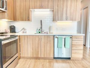 Una cocina con gabinetes de madera y toallas verdes. en City View Apartment In Downtown, en San Diego 6 fotos más