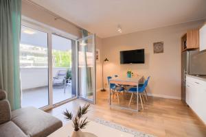 a living room with a dining room table and a kitchen at Studio 51 Baltic Park, 280m do Plaży, Duży balkon in Pogorzelica