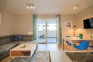 a living room with a couch and a table at Studio 51 Baltic Park, 280m do Plaży, Duży balkon in Pogorzelica