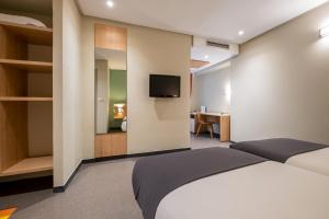 A bed or beds in a room at Manzil Hotel