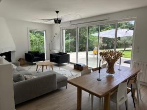 een woonkamer met een bank en een tafel bij Villa des 3 Ponts, Piscine au calme in Nîmes